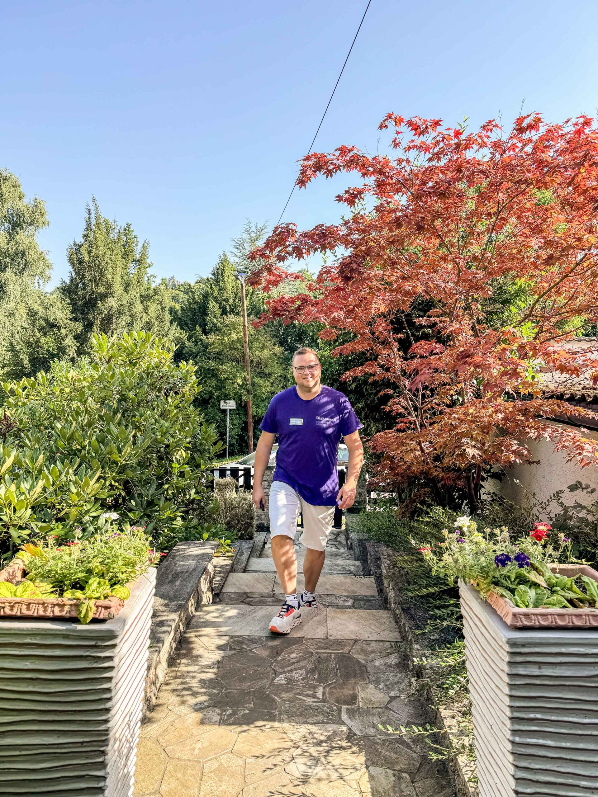 Freundlicher Mitarbeiter des Diakonie Pflegedienstes Eisenach läuft eine Treppe hoch