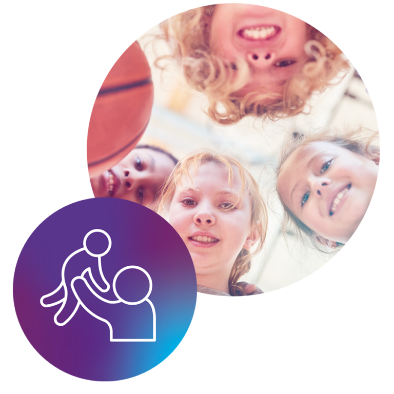 Eine Gruppe mit Jungen und Mädchen blickt lächelnd von oben nach unten in die Kamera und hält einen Basketball ins Bild