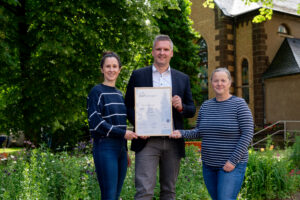 Vorstandsmitglied Tobias Reinhardt und unsere Referentin Nachhaltigkeitsmanagement übernehmen NAT-Urkunde von Grit Booth, Quelle NAThüringen