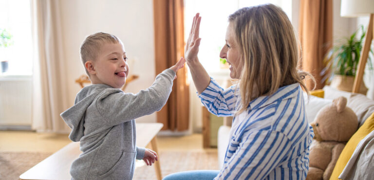 Mutter spielt mit ihrem kleinen Sohn mit geistiger Behinderung