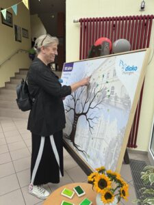 Brigitte Mompe, Einrichtungsleiterin des Diako Seniorenzentrums JOLIOT CURIE in Gera, füllt einen symbolischen Ausdruck eines Baums mittels grünem Fingerabdruck mit Laub