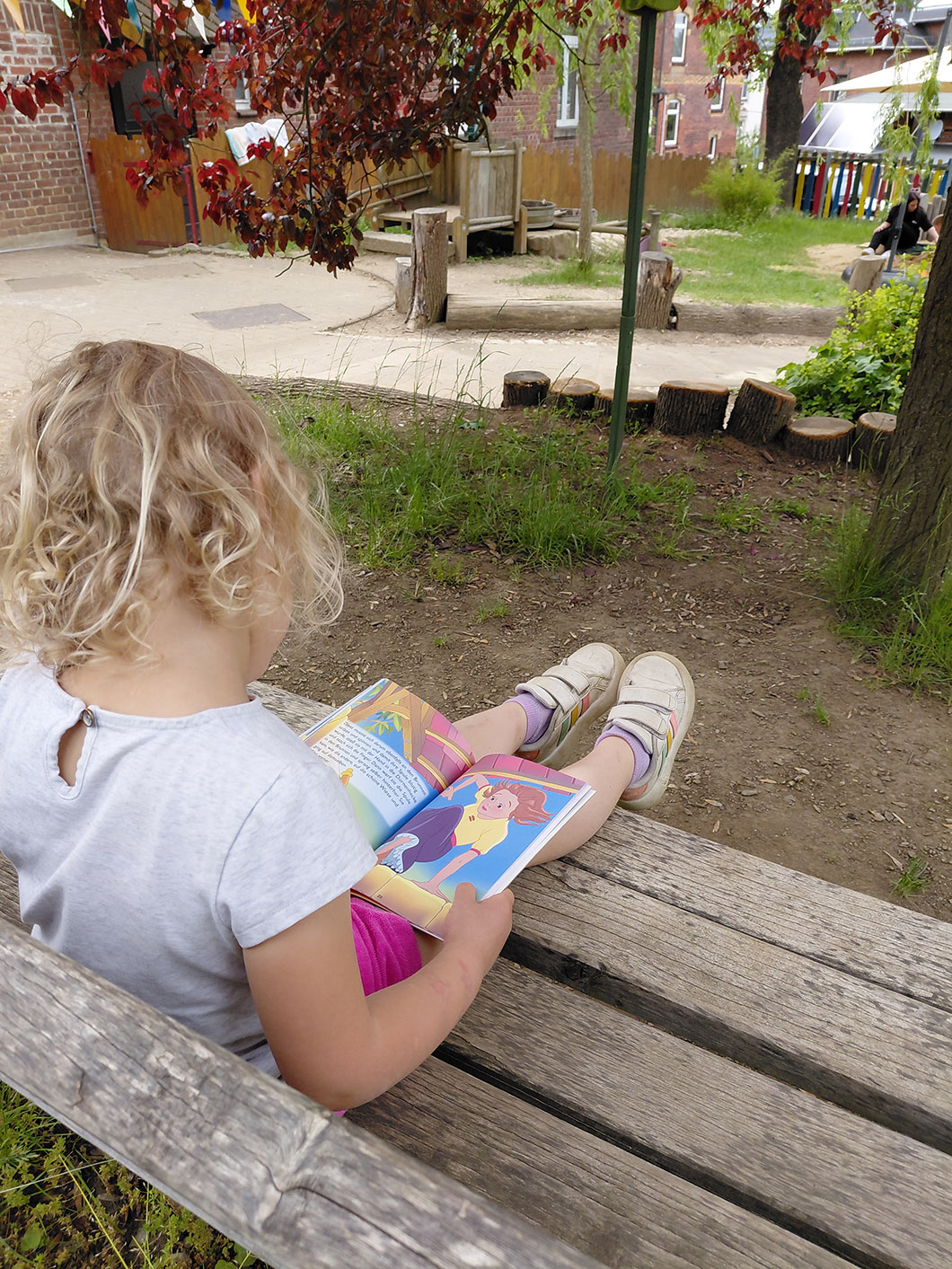 Evang. Kindergarten Schleiz_Kind blättet in einem Buch Wasserpumpe