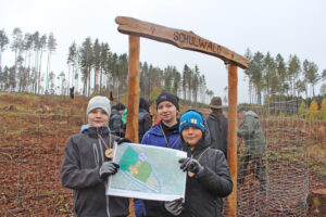 Freie Montessori-Gemeinschaftsschule Bad Lobenstein - Kinder im Schulwald, sie halten einen Pflanzplan