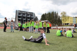 Freie Montessori-Gemeinschaftsschule Bad Lobenstein - auf dem Sportplatz, ein Junge sitzt im Gras, ruht sich aus