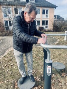 Tagespflege St. Martin Ebersdorf, ein Mann am Sportgerät im Garten