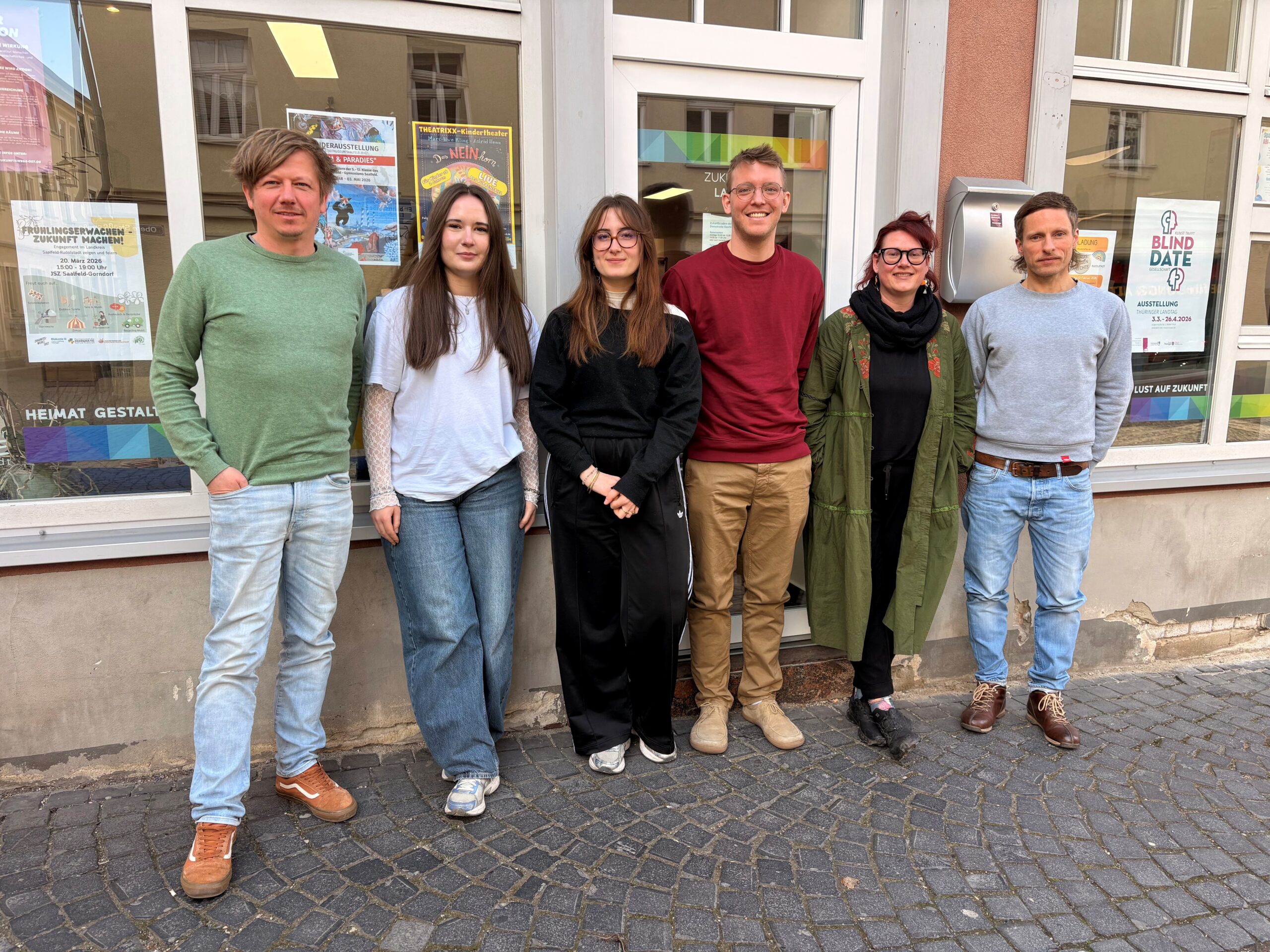 Zukunftsladen Saalfeld, Teambild, fünf junge Menschen stehen an einem Schaufenster