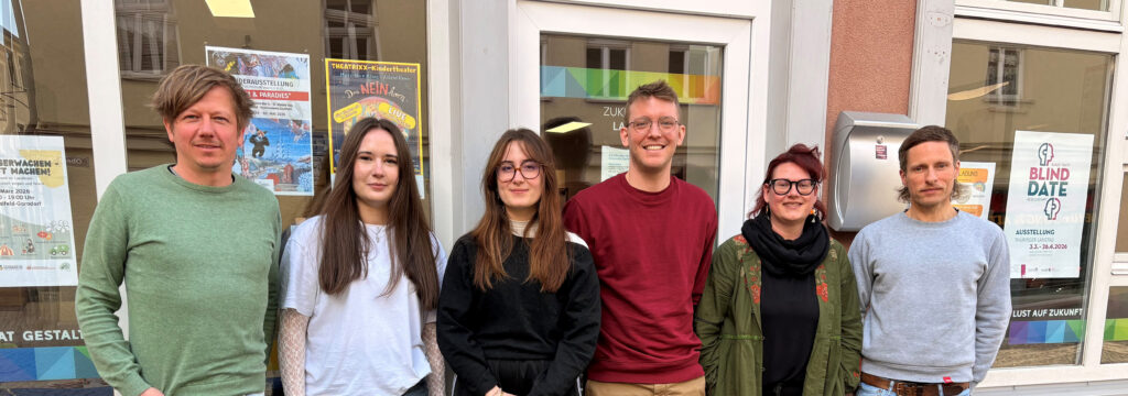 Zukunftsladen Saalfeld, Teambild, fünf junge Menschen stehen an einem Schaufenster