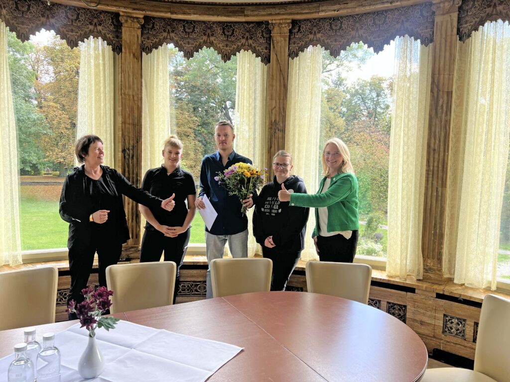 inclusio Weimar_fünf Personen stehen im Gobelinzimmer des Herrenhauses in Holzdorf