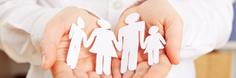 ThINKA Bad Lobenstein und Pößneck, Familie aus Papier liegt sicher in den Händen einer Frau