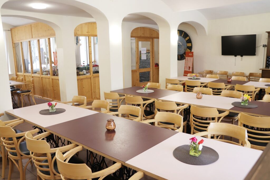 Cafeteria im Landgut Holzdorf, Blick in das Café. Tisch und Stühle, keine Menschen