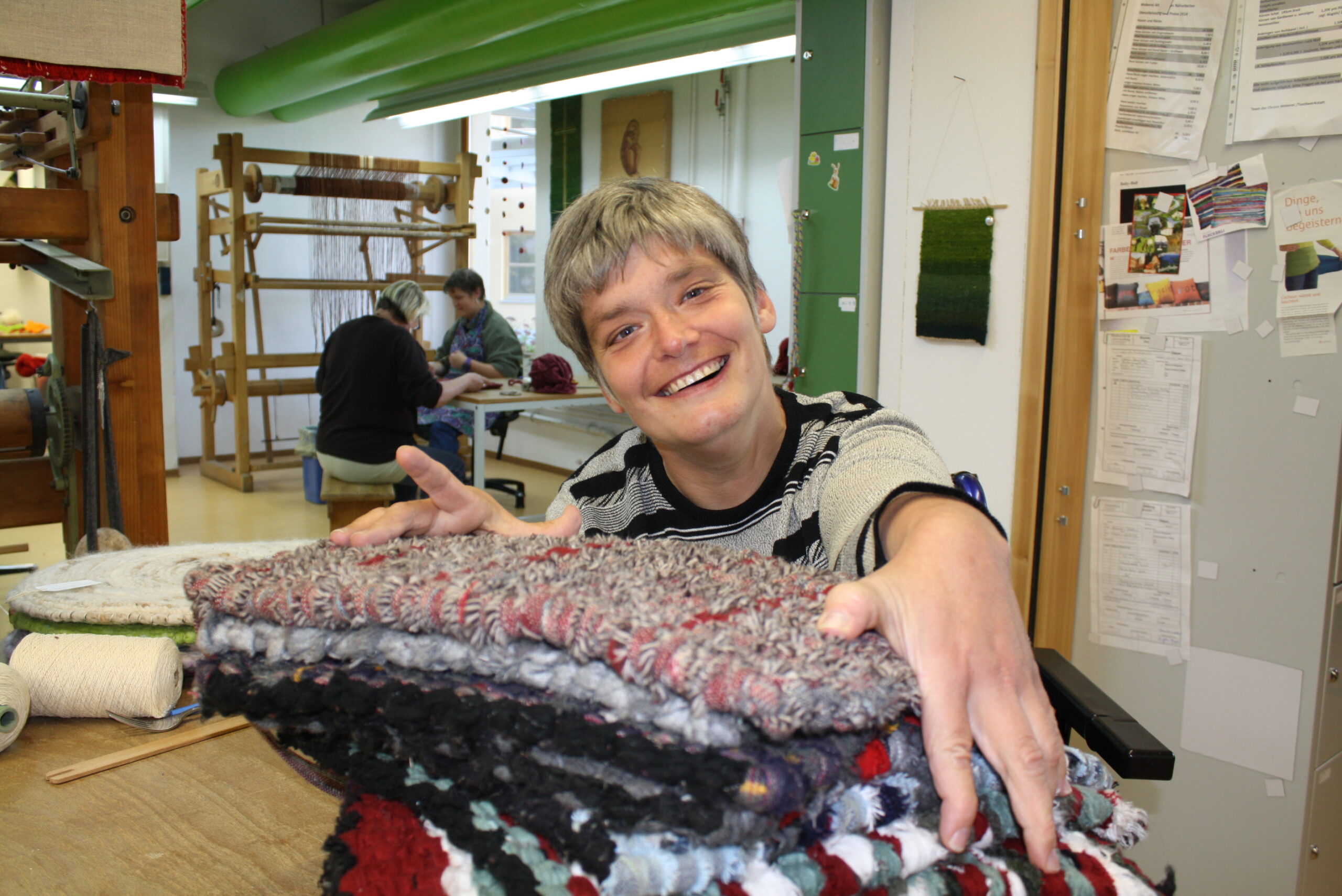 Weberei der Werkstätten Christopherushof in Altengesees, junge Frau mit gewebten Kissen
