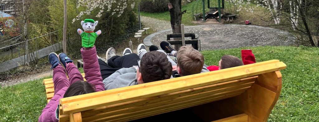 drei Jugendliche liegen auf einer Wellenbank