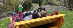 drei Jugendliche liegen auf einer Wellenbank