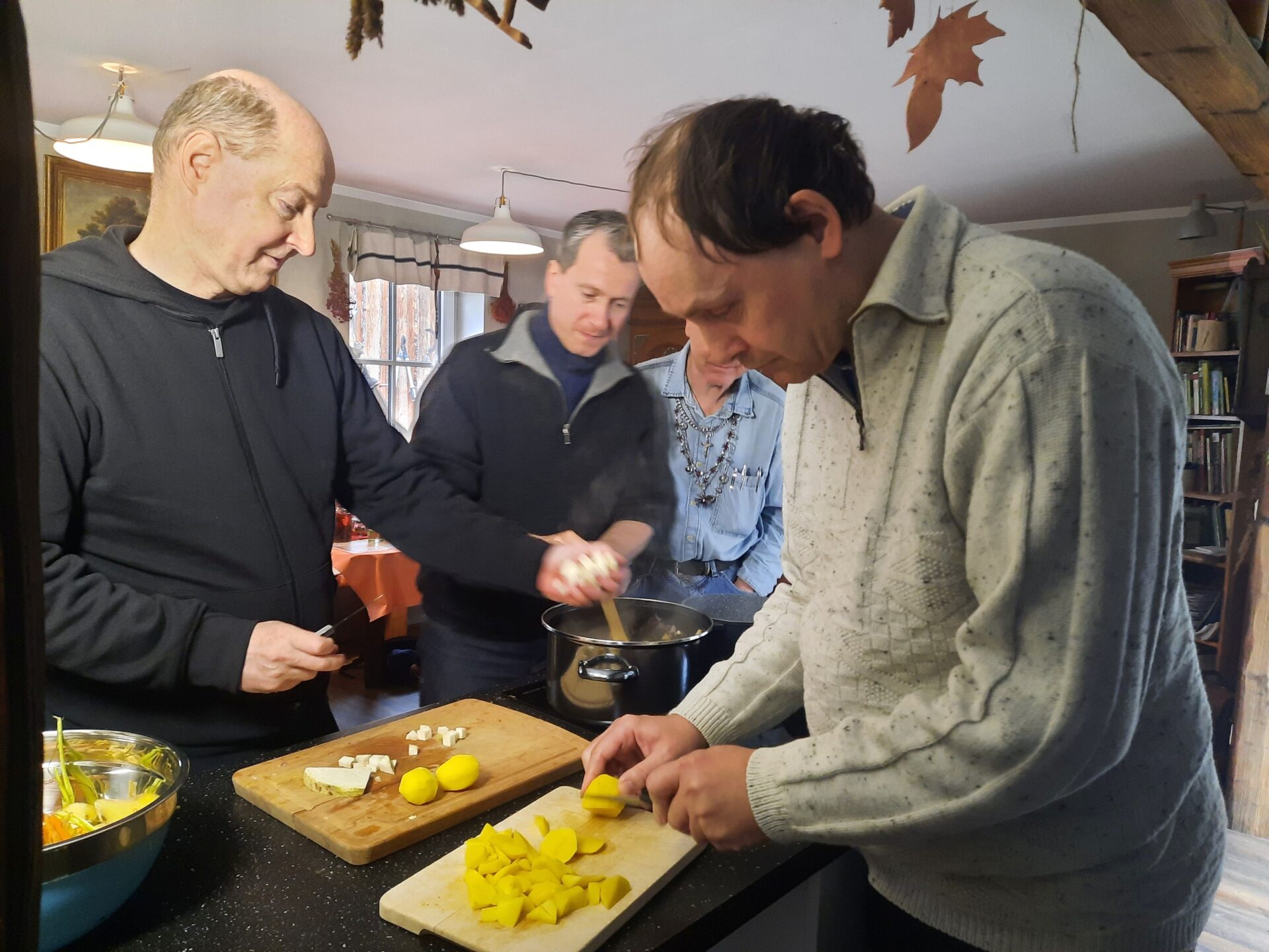 drei Menschen beim Kartoffeln schälen