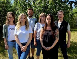 vier junge Menschen und zwei Lehrkräfte stehen in einer Gruppe