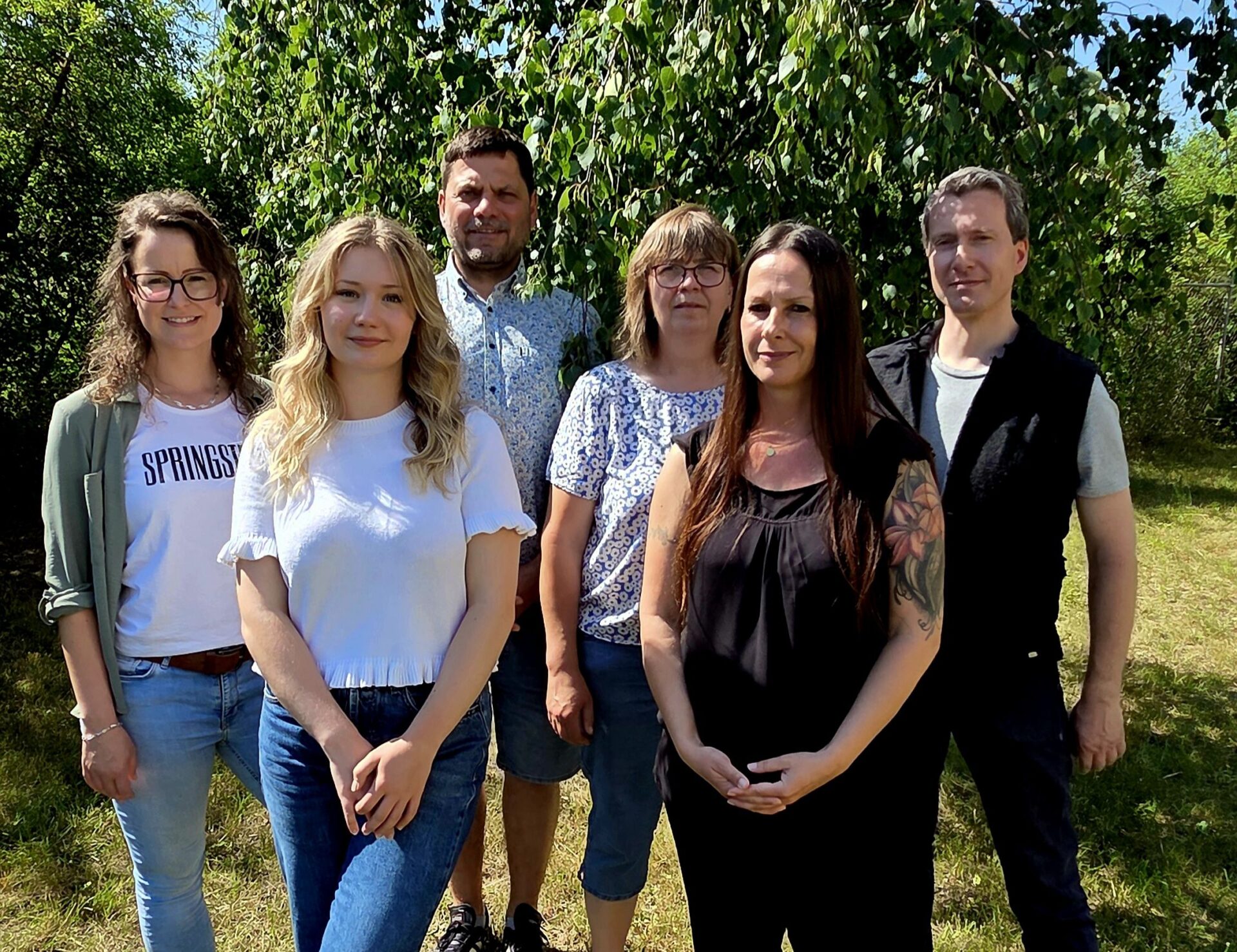 vier junge Menschen und zwei Lehrkräfte stehen in einer Gruppe
