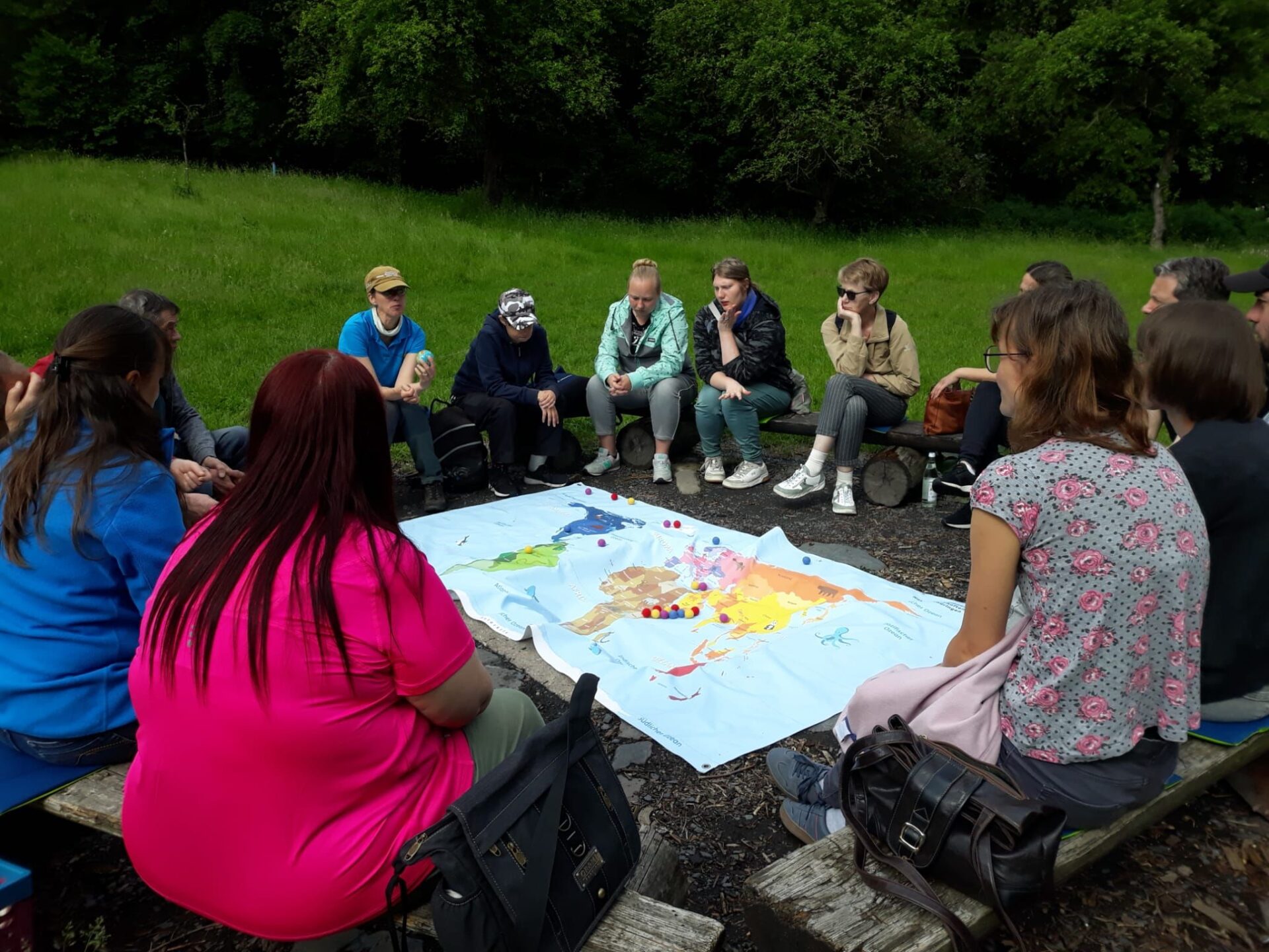 junge Menschen an einem Tisch im Grünen