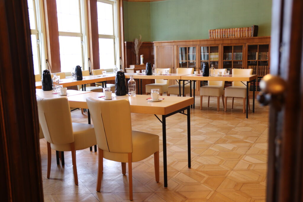 Landgut Holzdorf Blick in die Bibliothek-Tische zu einer Tafel in U-Form, weiße Stühle