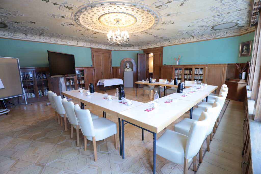 Landgut Holzdorf Blick in die Bibliothek-Tische zu einer Tafel in U-Form, weiße Stühle