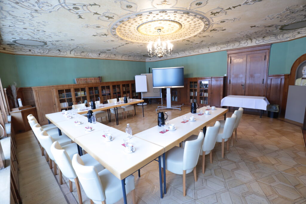 Landgut Holzdorf Blick in die Bibliothek-Tische zu einer Tafel in U-Form, weiße Stühle