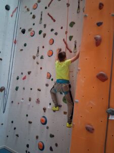 ein Mädchen beim Klettern in einer Bolderhalle