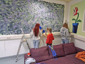 Kinder bei kreativen Arbeiten mit Pinsel und Farbe