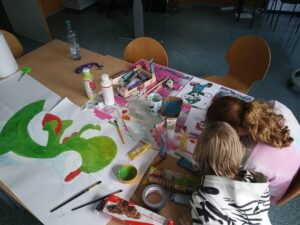 Kinder bei kreativen Arbeiten mit Pinsel und Farbe