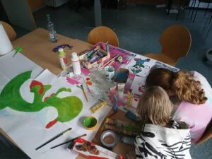 Kinder bei kreativen Arbeiten mit Pinsel und Farbe