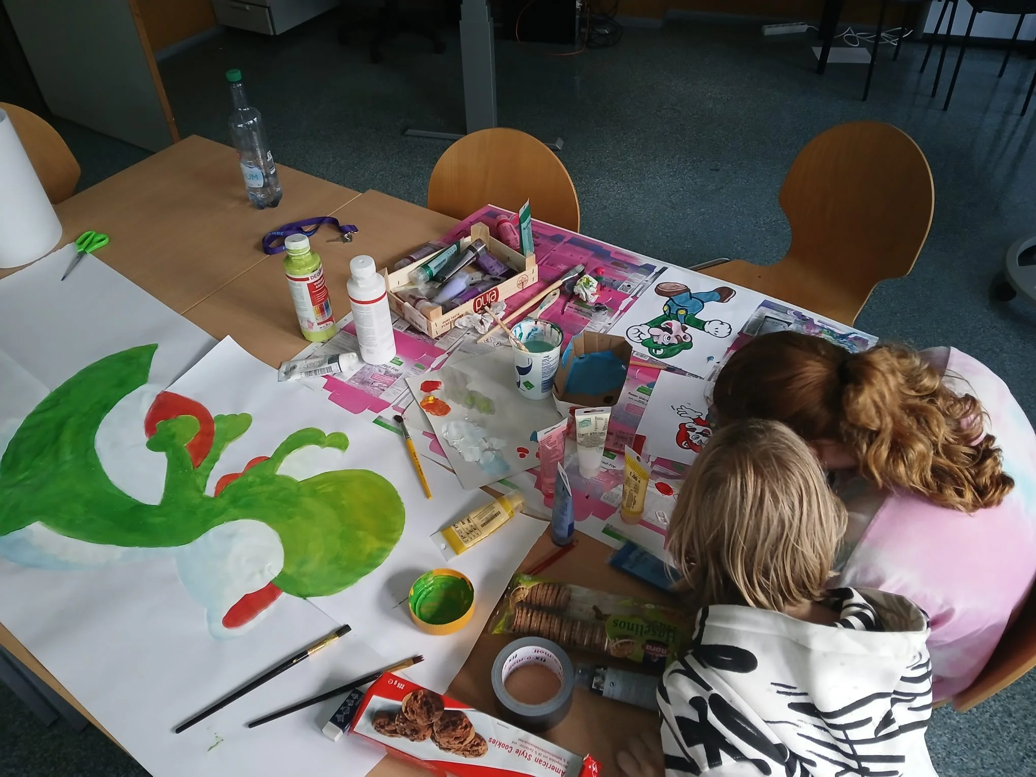Kinder bei kreativen Arbeiten mit Pinsel und Farbe