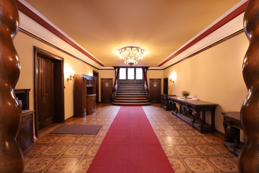 Landgut Holzdorf-Blick in das Foyer des Herrenhauses, roter Teppich, historische Holztür