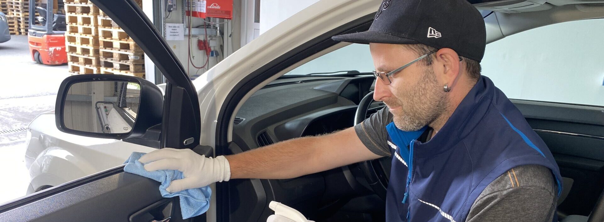 Saalfelder Werkstätten-Fahrzeugreinigung_Man wischt über das Amaturenbrett eines Fahzeuges