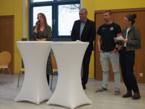 Frühlingsfest im Jugend- und Stadtteilzentrum Saalfeld, Menschen an Stehtischen bei einer Diskussionsrunde