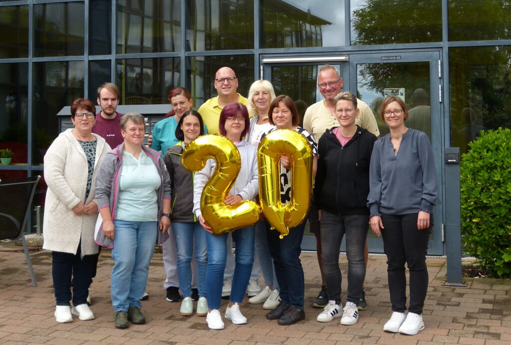 Wohnstift Kloster Donndorf, eine Gruppe Frauen und Männer hält eine 20 aus goldfarbenen Luftballons