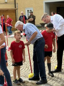 Spendenlauf der Michaelisschule Bad Lobenstein - ein Mann drückt einen Stempel auf ein Blatt am Rücken eines Schülers 
